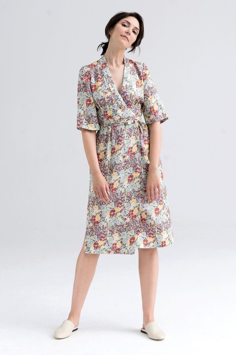 Kobieta w kwiecistej sukience midi z wiązanym pasem, idealna na codzienne stylizacje i self-care fashion