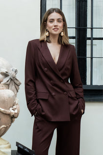 Kobieta w eleganckim garniturze w kolorze burgundowym, stylowa odzież damska z precyzyjnym krawiectwem