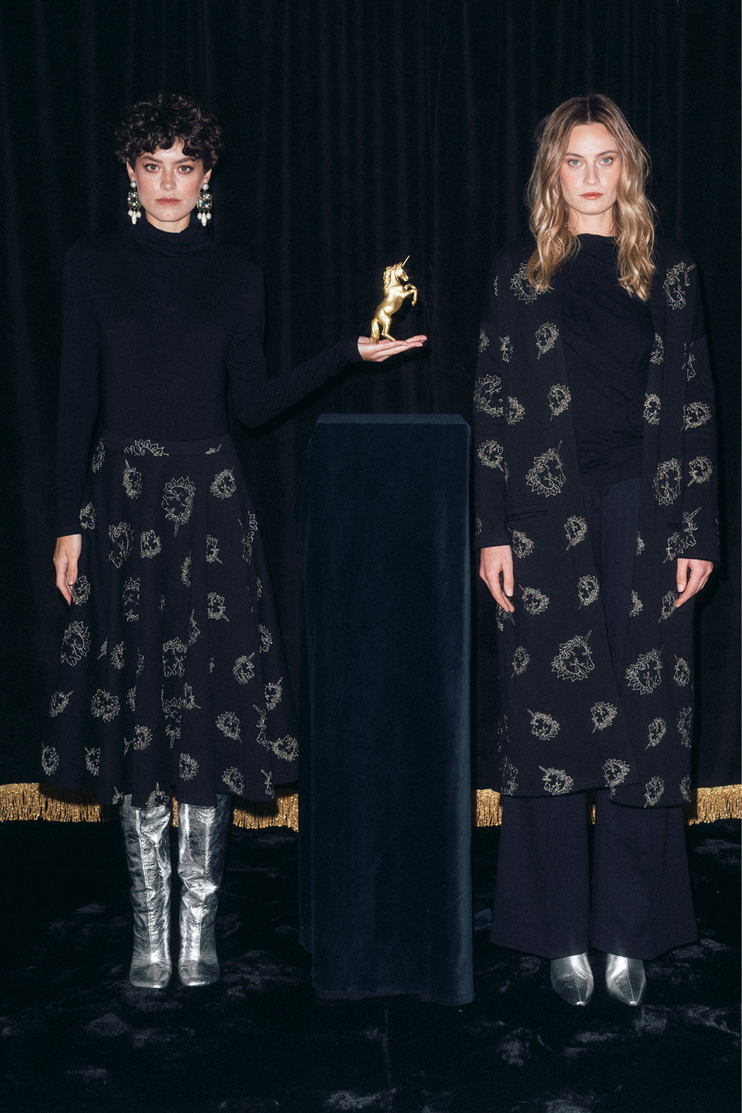 Dwie kobiety w eleganckich, czarnych strojach z złotym jednorożcem, stylowa moda polska