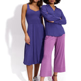 Dwie kobiety w fioletowych strojach: sukienka i bluza z szerokimi spodniami, stylowy look z komfortem
