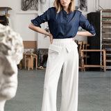 Kobieta w białych spodniach wide leg i granatowej koszuli, stylowy strój na co dzień, moda polska