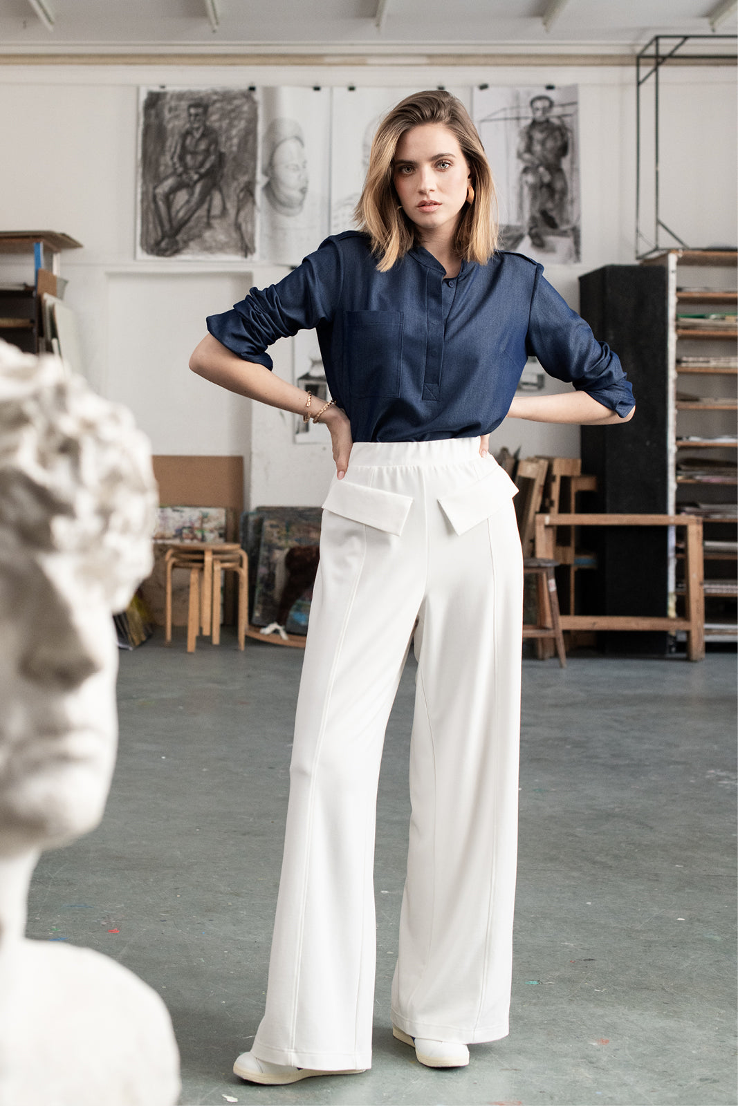 Kobieta w białych spodniach wide leg i granatowej koszuli, stylowy strój na co dzień, moda polska