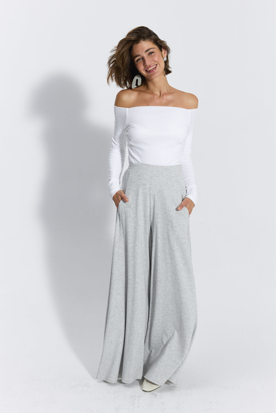 Szare spodnie dresowe typu wide leg z białą bluzką off-shoulder, stylowy i wygodny strój damska moda