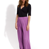 Fioletowe spodnie damskie z wysokim stanem i czarna bluzka z dekoltem w szpic, stylowe i wygodne
