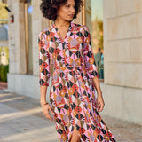 Kobieta w kolorowej, geometrycznej sukience z pasem, stylowa moda uliczna, wygodna i elegancka